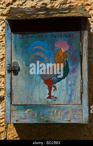 Eine bemalte hölzerne Briefkasten mit einem bunten Hahn außerhalb eines Dorfhauses in der Provence. Süden von Frankreich Stockfoto