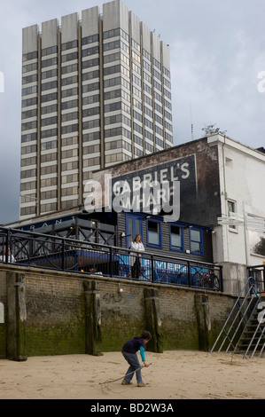 Ein Junge spielt am Strand von der Themse bei Ebbe mit Gabriels Wharf und Kent House (HQ von ITV) im Hintergrund Stockfoto