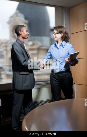 Mann, Frau, Händeschütteln im Büro Stockfoto