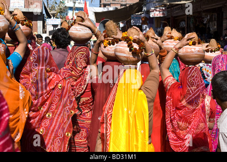 Indische Frauen, die Angebote auf ihren Köpfen während eines Festes von Rajasthan, Pushkar, Indien Stockfoto