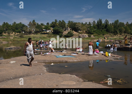 Menschen waschen und die Wäsche in einem Fluss, Hampi, Indien Stockfoto