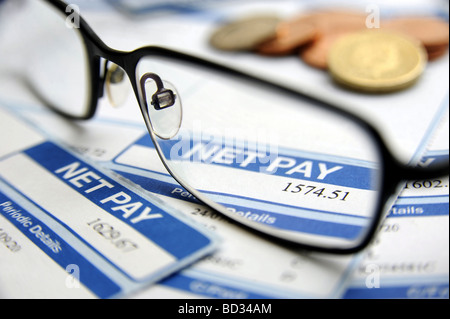 BRITISCHE GEHALTSABRECHNUNG ZEIGT MONATLICHEN NETTOLOHN MIT BRILLE UND GELD WIEDER REZESSION DURCHSCHNITTSEINKOMMEN KREDITKLEMME RECHNUNGEN KOSTEN ETC. UK Stockfoto