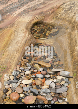 Buntes Wasser getragen Steinen Pebbels im Felsenbad bei Ebbe gefangen genommen Stockfoto