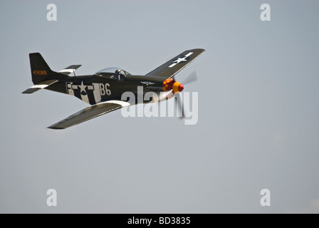 Ein p-51 Mustang fliegt auf einer Airshow, dieser Mustang hat Invasion Streifen gemalt. Stockfoto