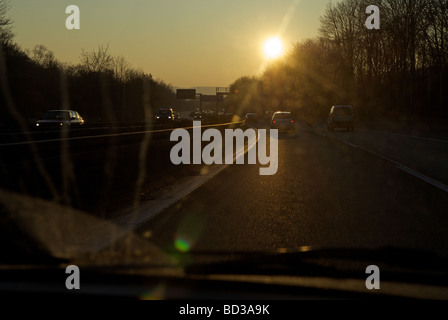 Das fahren in einer untergehenden Sonne auf einer Autobahn, Nordrhein-Westfalen, Deutschland. Stockfoto