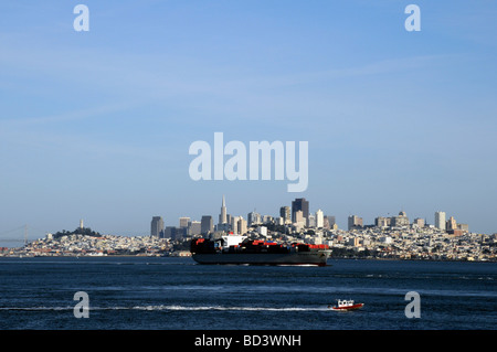 Massive Containerschiff Zwerge der Küstenwache mit der Stadt von San Francisco am Horizont. California Stockfoto