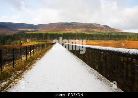 Eine Prise Schnee auf einem Wanderweg über den Damm am Torside Stausee im Tal Longdendale in Derbyshire Stockfoto