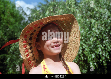 Kleines Mädchen in einem Vintage Sonne Hut lächelnd.  Ihre zwei Vorderzähne fehlen.  Sie müssen mit der Zahnfee sein. Stockfoto