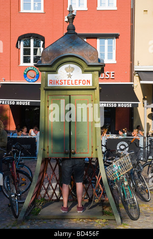 Mann, der einen Anruf von einem altmodischen Telefon box in Malmö Skåne Schweden Europa Stockfoto