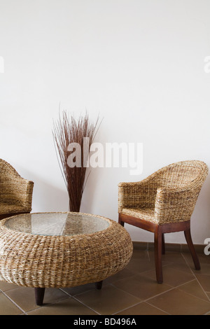 Wicker Tisch und Stühle gegen eine weiße Wand mit Textfreiraum Stockfoto