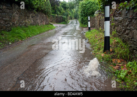 Wasser sprudelt aus Abfluss und liefen Feldweg nach starken Regenfällen. Stockfoto