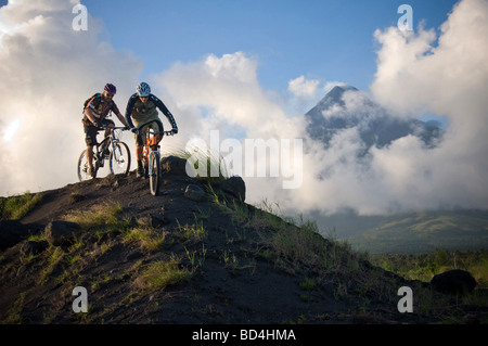 Professionelle Mountainbiker Hans Rey und Brian Lopes am Vulkan Mount Mayon, Philippinen Stockfoto