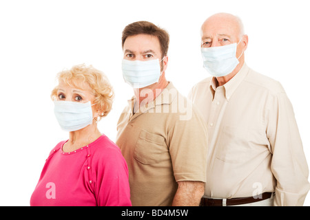 Älteres Paar und ihr erwachsener Sohn tragen Mundschutz zum Schutz vor Grippe-Epidemie isoliert Stockfoto