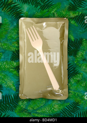 Ein Kunststoff-militärische Lebensmittel rationieren Paket mit einer Plastik Gabel auf einem Hintergrund von grünen Tarnung Stockfoto