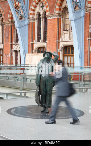 Ein Passagier geht vor der Statue von Sir John Betjeman in der neuen St. Pancras International Station, London, UK. Stockfoto