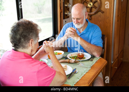 Älteres paar sagen ein Gebet des Dankes über eine Truthahn-Abendessen in ihrem Wohnmobil Stockfoto