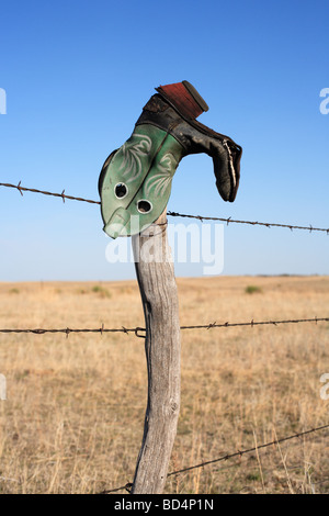 Eine Upside-down Cowboy-Stiefel auf einer Ranch Zaun im ländlichen Nebraska, USA. Stockfoto