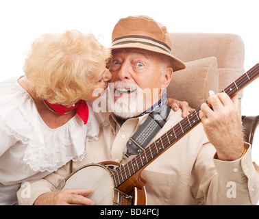 Ältere Mann spielt Banjo für seine Frau ist mit einem Kuss belohnt. Stockfoto