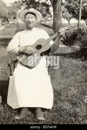 Cross Dressing älteren Mann spielt Gitarre Stockfoto
