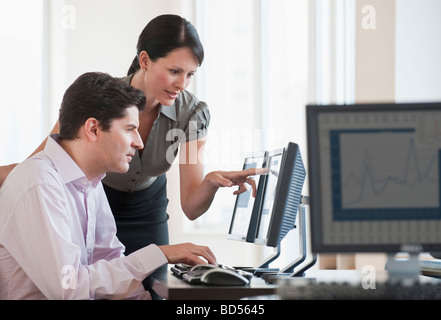 Zwei Geschäftsleute, die mit Hilfe eines Computers Stockfoto