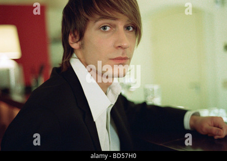 Gut gekleidete junge Mann an der bar, Blick in die Kamera Stockfoto