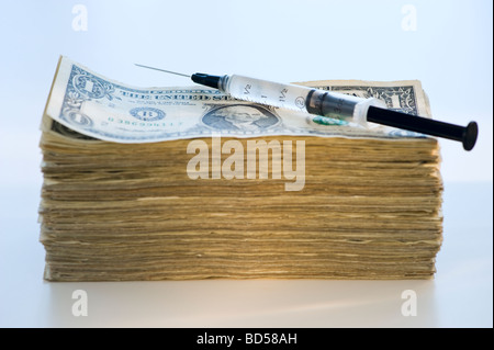 Eine Spritze auf ein Stapel von Banknoten Stockfoto