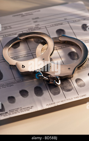 Handschellen auf einer Seite von Fingerabdrücken Stockfoto