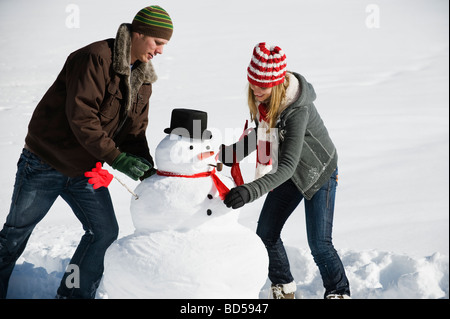 Ein paar macht einen Schneemann Stockfoto