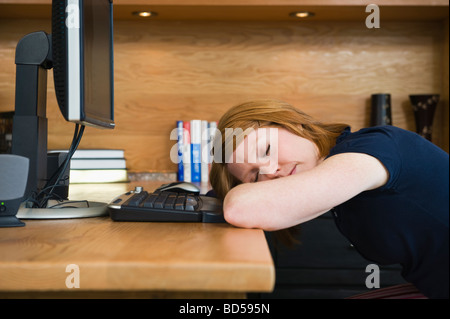 Eine Frau schläft in einem home-office Stockfoto