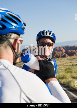 Biker auf der Straße unter einer Pause Trinkwasser Stockfoto