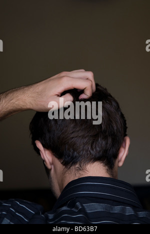 Rückansicht eines Mannes Kopf kratzen Stockfoto