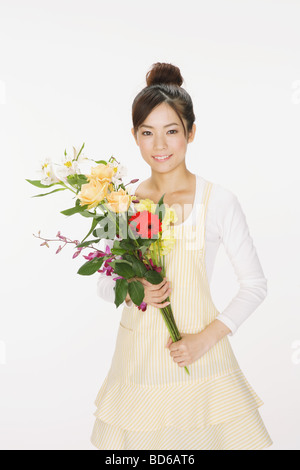 Frau hält einen Blumenstrauß und lächelnd Stockfoto
