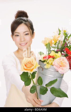 Junge, lächelnde Blume geben Frauen Stockfoto