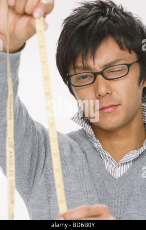 Junger Mann Analyse Maßband Stockfoto