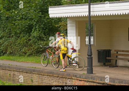 2 ältere Radfahrer ruhen auf den stillgelegten Bramley und Wonersh Bahnhof auf den Downs verknüpfen Stockfoto