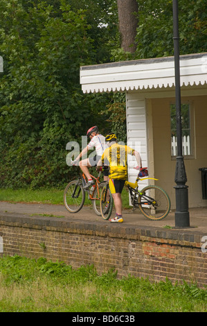 2 ältere Radfahrer ruhen auf den stillgelegten Bramley und Wonersh Bahnhof auf den Downs verknüpfen Stockfoto