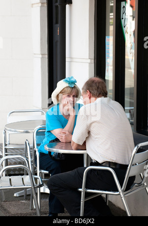 Mann und Frau sitzen an einem Tisch vor einem café Stockfoto