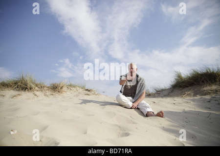 Männlichen Best Ager sitzen in den Dünen an der Nordsee in De Haan, Belgien Stockfoto