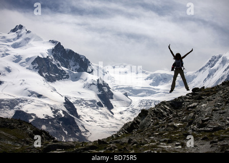 Junge Frau springt in Gornetgrat Gletscher der Schweiz Stockfoto