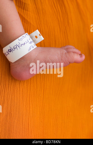 Neugeborenes Baby Fuß mit Tag um den Knöchel im Krankenhaus Stockfoto