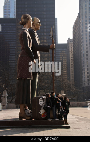 Junge Touristen posieren für Fotos auf "God Bless America" von J. Steward Johnson, inspiriert von Grant Wood "American Gothic. Stockfoto