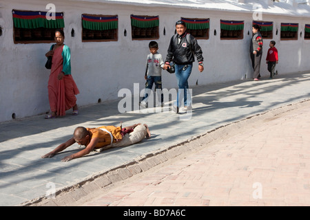 Bodhnath, Nepal.   Eine buddhistische Anhänger sucht Verdienst, Segen und Vergebung durch einkreisen der Stupas in einer Reihe von Niederwerfungen. Stockfoto