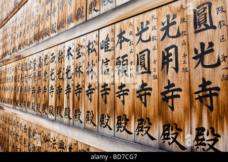 Holztafeln mit japanischer Schrift auf dem Display vor einem Tempel in Kyoto, Japan Stockfoto