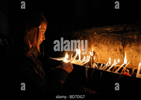 Ein junges Mädchen zündet Kerzen in der Kirche des Heiligen Grabes an, in der christlichen Altstadt Ostjerusalem Israel Stockfoto