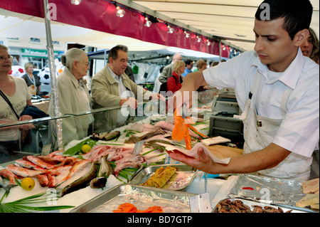 Paris Frankreich, Menschen, Shopping in außerhalb öffentlicher Lebensmittelmarkt, Stall, Display, frischen Fisch junge männliche Angestellte Portion Lachs, Straße Stockfoto