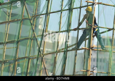 Arbeiter stehen in Bambus-Gerüst auf einer Baustelle in Hong Kong Stockfoto