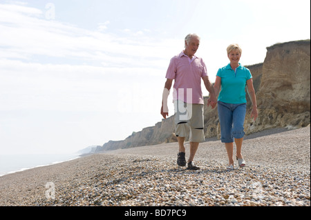 Älteres Paar zu Fuß am Kiesstrand Stockfoto