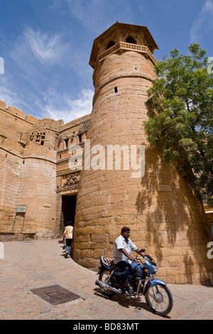 Ein Mann auf einem Motorrad verlässt durch das Haupttor des Kastells in Jaisalmer, Rajasthan Stockfoto
