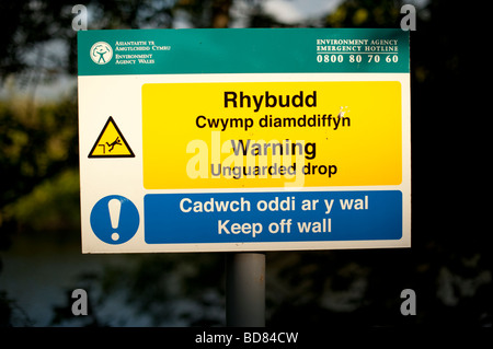 Zweisprachige walisische englische Zeichen Warnung des unbewachten Tropfen von der Umwelt Agentur Wales ausgestellt Stockfoto
