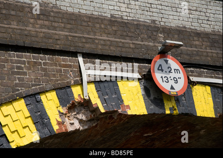 Niedrige Brücke Warnschild am Ziegel Eisenbahnbrücke Stockfoto